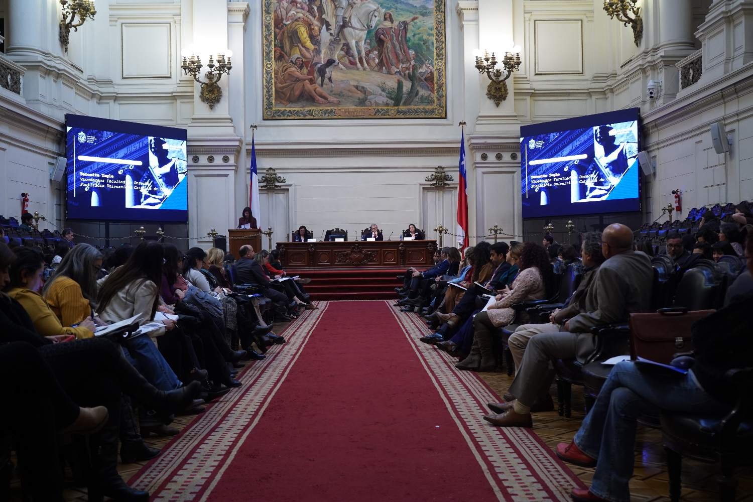 Seminario de derecho de familia en un salón institucional, con panel de expositores y audiencia
